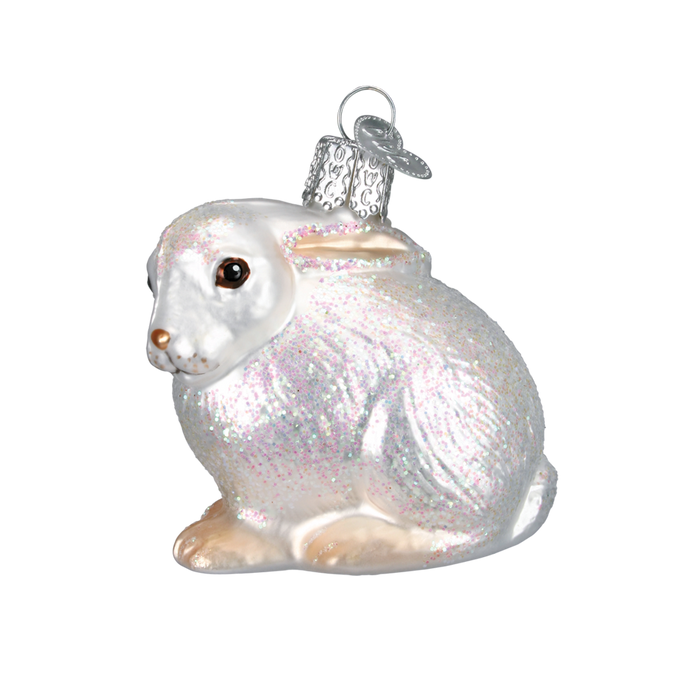 The Cottontail Bunny 12192 Old World Christmas Ornament Assorted features a glittery, hand-painted white bunny with a silver cap and hanging loop—a charming glass piece perfect for your holiday décor.