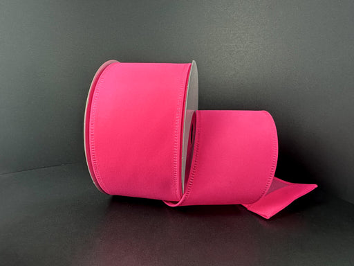 A 2.5 by 10 yard hot pink velvet ribbon (131840-44) is partially unspooled and displayed against a plain black background.