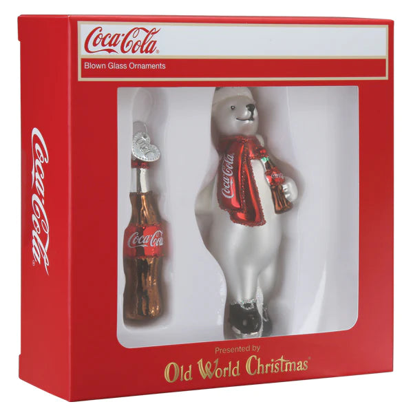 The Coca-Cola Polar Bear Set Old World Christmas Ornaments 14033 includes a boxed set of festive decorations, featuring a delightful polar bear holding a Coke bottle and accompanied by an additional ornament shaped like a classic Coke bottle. The vibrant red packaging prominently showcases the Coca-Cola branding, with Old World Christmas featured at the bottom.