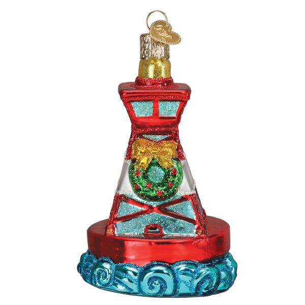 The Holiday Buoy Old World Christmas Ornament 36330 features a colorful glass lighthouse buoy with red, blue, and gold accents, a green wreath at its center, and blue waves surrounding the base.
