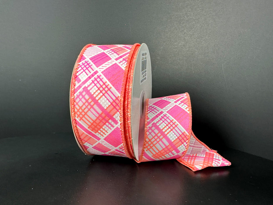 Two rolls of 1.5X10Y Cabot Printed Plaid Ribbon in peach, orange, pink, and white on black; one larger than the other with a length unfurled. Both are wired for adding structure to crafts.
