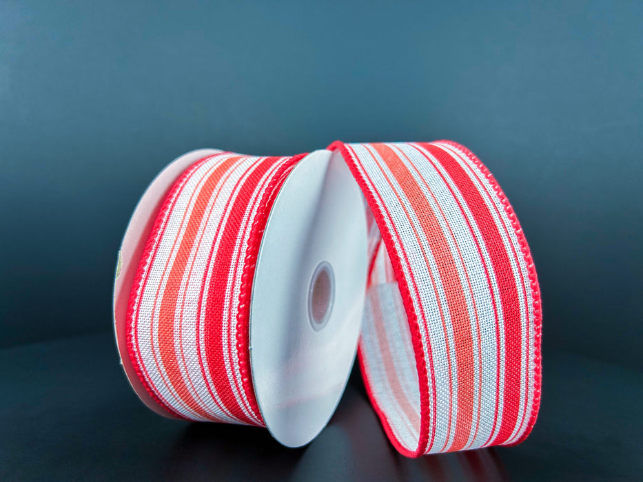 Two rolls of 1.5X10Y White Coral Melon Linen Ticking Stripes Ribbon are upright against a dark background. The ribbons, rolled on white spools, highlight colorful, shiny textures reminiscent of classic ticking stripes.