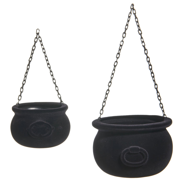 Two 10" Black Flocked Cauldrons (4540882) with textured surfaces hang from metal chains against a white background. Ideal for Halloween decor, each cauldron features a circular front design for festive flair.