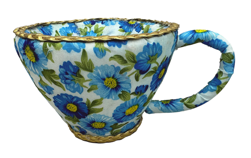 The 4H X 6W Blue Tea Cup Ornament (63725BL) showcases a uniquely shaped teacup with a wide opening, featuring a vibrant blue and green floral pattern with a gold braided design on the rim and handle for added elegance.