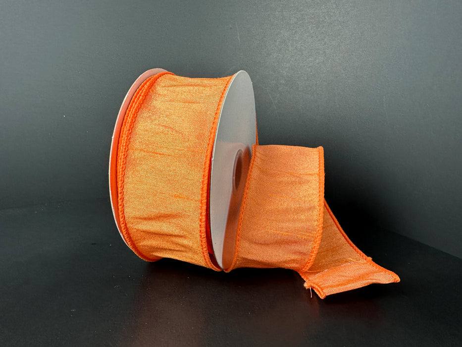 A partially unraveled spool of Peach Faux Dupioni Ribbon (1.5X10Y) features a subtle sheen on a dark background, with slightly gathered edges enhancing its delicate look.