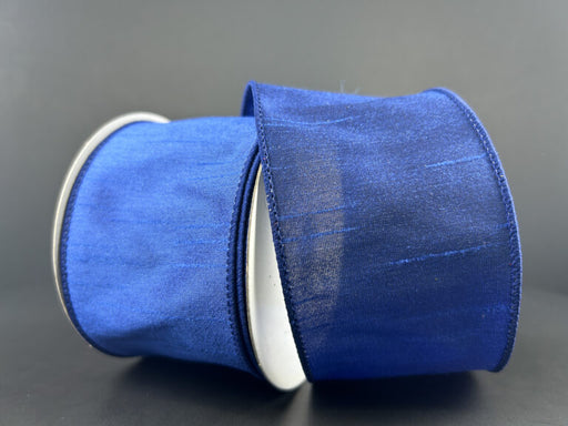 Two rolls of 2.5X10Y Navy Faux Dupioni Ribbon (72434-40-27) with a subtle sheen stand against a dark background. The neatly stitched edges are visible, and one roll is slightly tilted, overlapping the other.