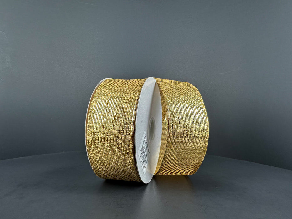 Two rolls of 1.5X10Y Gold Stairstep Woven Metallic Ribbon (76310-09-15) with white centers stand upright on a dark gray background, their glittery metallic stairstep design reflecting the light.
