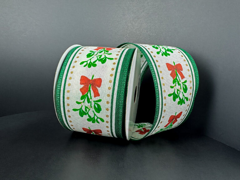 Two rolls of 2.5x10Y Ivory Linen/Mistletoe Bow/Green Edge Ribbon (76502-40-07) are displayed on a dark gray surface with a gray background.