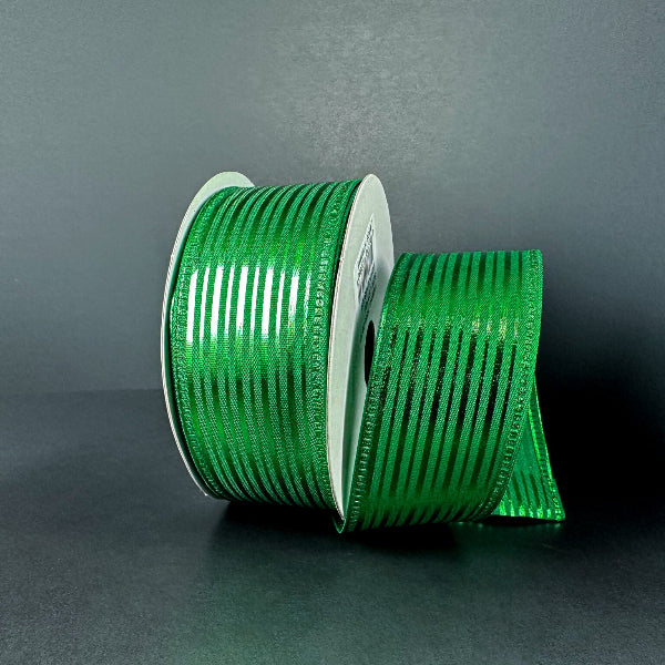 A spool of 1.5X10Y Emerald Satin/Metallic Embossed Vertical Grain Ribbon (76555-09-17) with horizontal black stripes stands upright on a dark surface, some ribbon unrolled nearby, set against a plain gray background.
