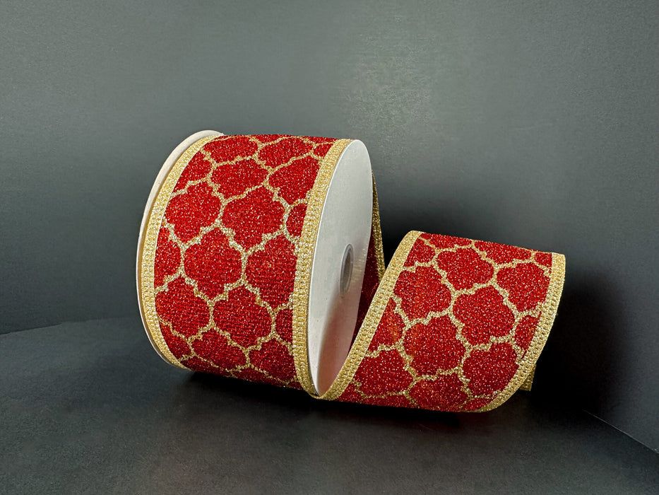 The 2.5X10Y Red Fuzzy Metallic/Gold Quatrefoil Ribbon (76574-40-15) features a glittery gold quatrefoil pattern and gold edges on red, elegantly displayed partially unrolled against a dark background.