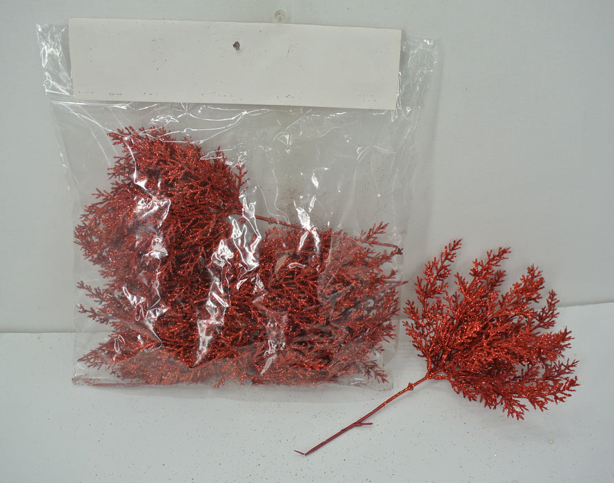 A clear plastic bag holds multiple 14 Red Lavender Picks with Glitter (84786-RD). One glittery, fern-like red branch is shown outside the bag on a white surface, displaying its detailed artificial foliage.
