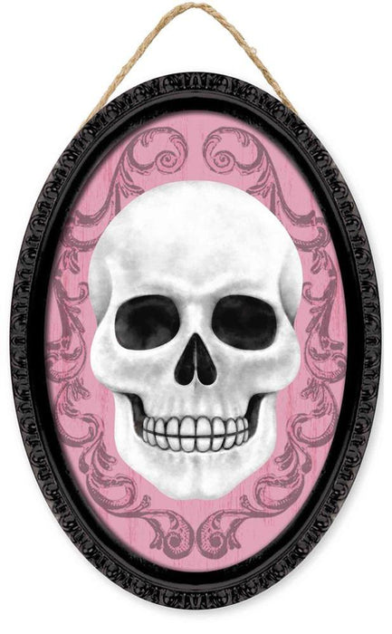 The 13Hx9L Framed Skull Oval Sign (AP729715) features a white skull on light pink with dark swirls, set in a black MDF/paper frame and hung by brown twine.