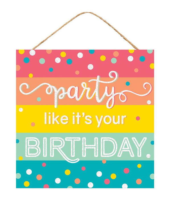 The 10Sq Glitter Party/Birthday Sign Pastel Multi AP783061 features vivid stripes in pink, orange, yellow, green, and blue with Party like its your BIRTHDAY in white. The backdrop is dotted with multicolored polka dots for lively pastel décor and hangs by a rope.
