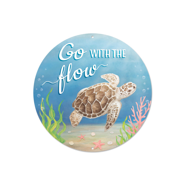 The 8Dia Metal Go With The Flow Sign Blue/Brown/White MD1386 features a sea turtle swimming near coral and seaweed on a sandy ocean floor with bubbles, and Flow Sign is etched in playful white font against the blue, brown, and white background.