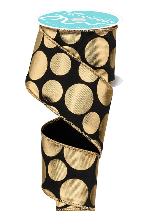 A roll of 2.5"X10Yd Gold 3 Size Multi Dots Black/Gold RGF113602 ribbon, featuring large, shiny polka dots on a black background, is partially unwound and elegantly displayed vertically on a white surface.