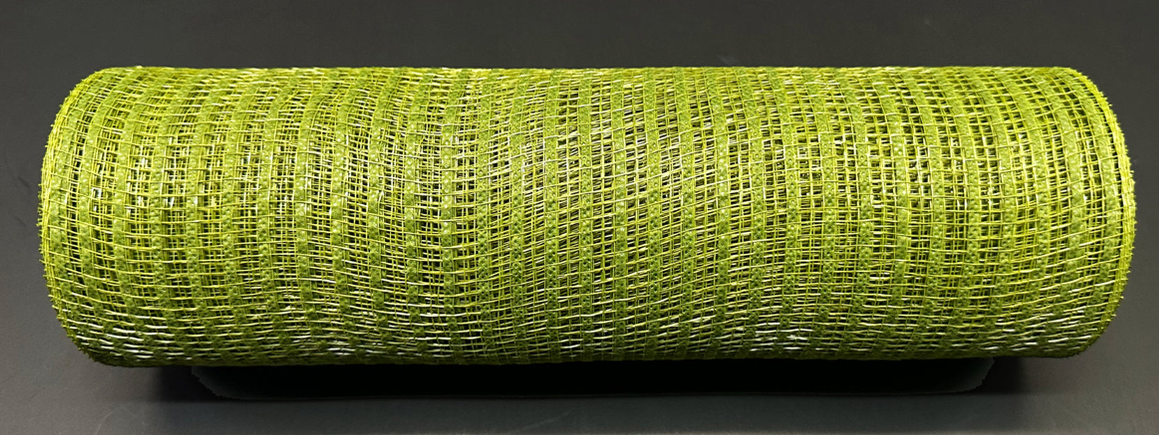 A roll of Moss Breeze Solid Mesh XB240710-08 sits on a dark background, showcasing a captivating interwoven fiber pattern in its green 10X10Y design.