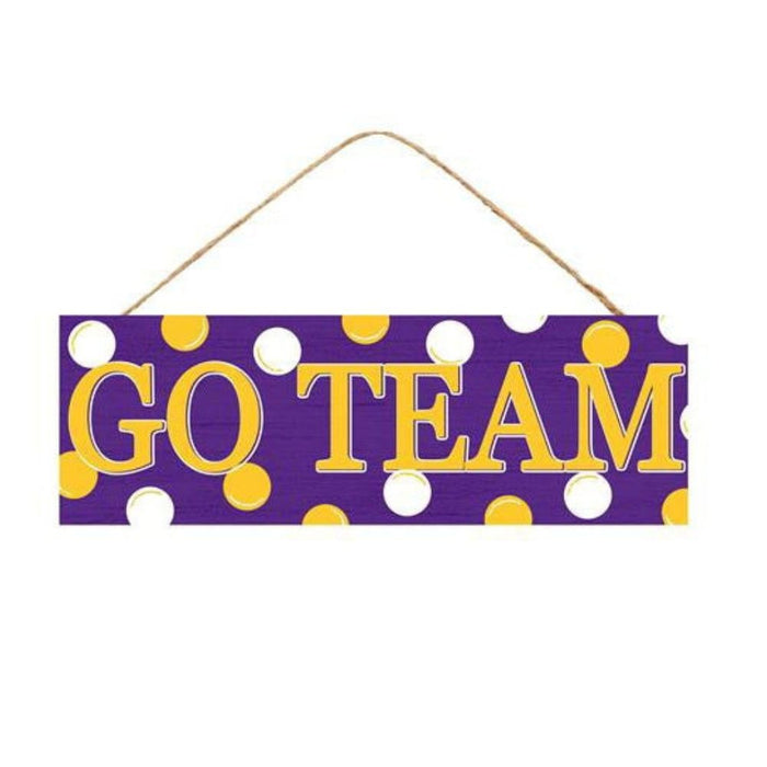The Purple Yellow Go Team Assorted Wall Hanging (AP807899) features a rectangular MDF sign with a vibrant purple background, adorned with cheerful yellow and white polka dots. GO TEAM is displayed in bold yellow letters and stylishly hangs on a brown string, ready to energize any room.