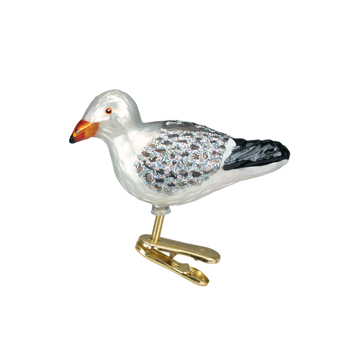 The Sea Gull Ornament Old World Christmas Ornament 18037 features a white body, black-tipped wings, and silver glitter, finished with a gold clip. Perfect for adding coastal style to your holiday décor.