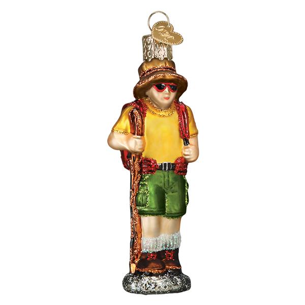 The Hiker Old World Christmas Ornament 24199 is a glass ornament shaped like a hiker with a hat, sunglasses, yellow shirt, green shorts, hiking boots, red backpack, walking stick, and glittery details—an ideal gift for hikers.