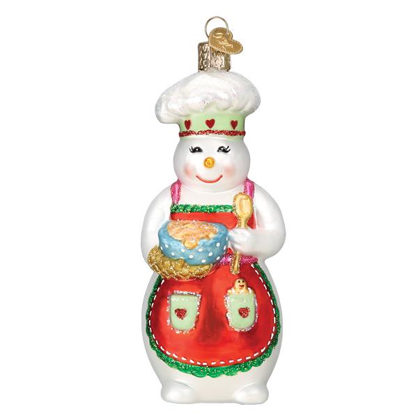 The Snow Woman Chef Ornament Old World Christmas Ornament 24208 features a smiling snow woman in a chef hat with heart details and red apron, holding a blue mixing bowl and gold spoon.