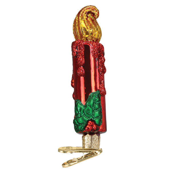 The Red Clip-on Candle Ornament by Old World Christmas (32521) features a shiny red candle with gold flame, wax drips, green holly leaves, berries, and a gold clip, making it a festive addition to your Christmas tree.