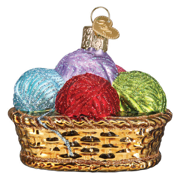 The Basket Of Yarn Ornament by Old World Christmas (32530) is a shiny golden knitting basket with four glittery blue, purple, red, and green yarn balls and a gold hanging loop at the top.