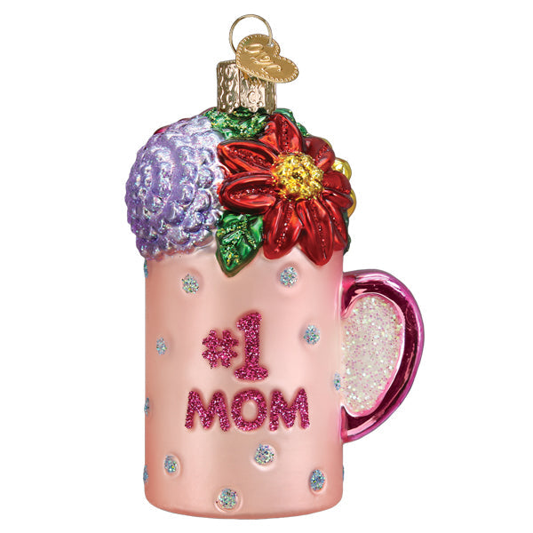The Best Mom Mug Ornament by Old World Christmas (32543) features a pink mug with glittery polka dots, #1 MOM on the front, a pink handle, colorful flowers on top, and a gold hanging loop—perfect for Mother’s Day.
