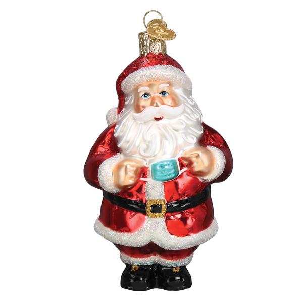 The Santa Revealed Ornament (Old World Christmas 40322) is a shiny glass ornament shaped like Santa in red, holding a blue face mask, with a gold cap and hook for hanging.