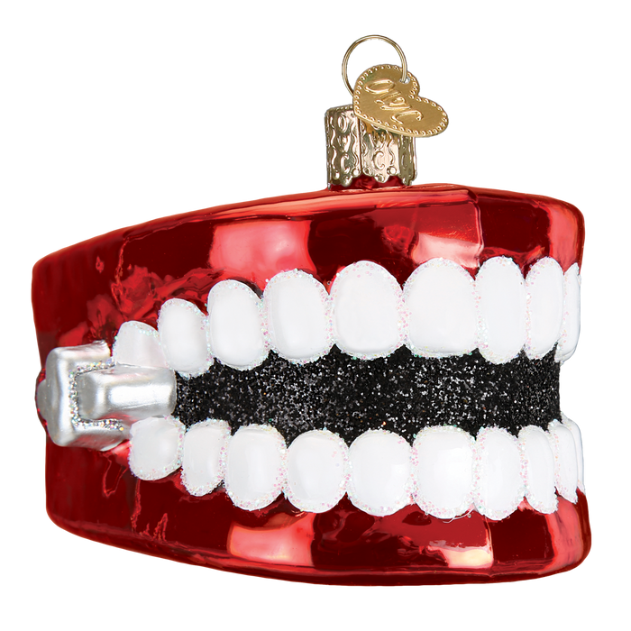 The Wind Up Teeth Ornament Old World Christmas Ornament 44107 features bright white teeth, a shiny red base, and a gold hanging cap—perfect for adding festive fun to your tree.