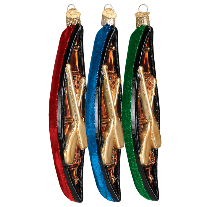 Three Canoe 46033 Old World Christmas Ornaments—red, blue, and green with gold paddles—hang side by side. Each hand-painted glass ornament adds Old World Christmas charm to your holiday décor.