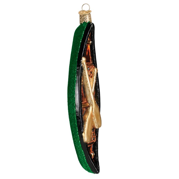 The Canoe 46033 Old World Christmas Ornament Assorted features a hand-painted green and brown glass exterior, two gold crossed paddles inside, and a gold hanging loop.