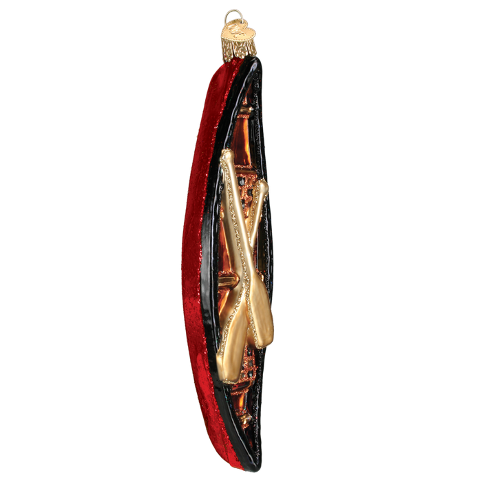 The Canoe 46033 Old World Christmas Ornament Assorted is a hand-painted glass decoration featuring a red canoe with black rim and gold crossed paddles—an enchanting addition to your holiday décor.