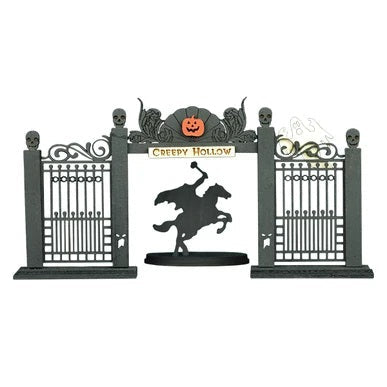 The Creepy Hollow GB103 Old World Christmas Ornament 82002 features black iron gates with skulls, a “Creepy Hollow” sign with a pumpkin, and the Headless Horseman on a rearing horse at the center.