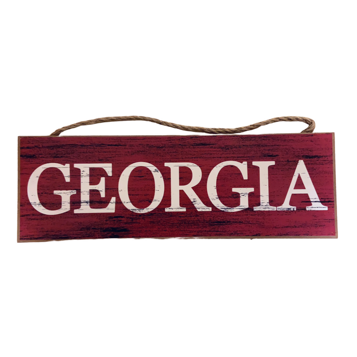 The Red Black Georgia or Go Team Assorted Wall Hanging AP809899 features a rectangular MDF wooden sign with a red background and visible grain patterns, displaying GEORGIA in large white capitals, and is suspended by a brown rope.