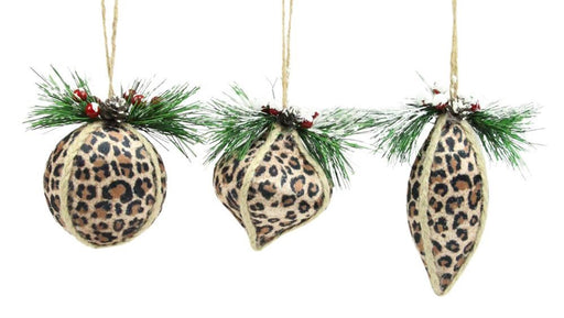 The 4" Leopard Print Fabric Ornament Set Of 3 (Beige/Black/Brown XY946501) features three ornaments with leopard patterns, each topped with faux pine, red berries, and snowy details. They hang on strings against a white background.