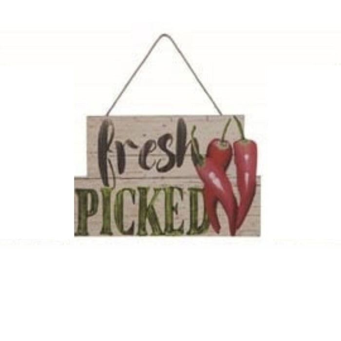 The Wood Vegetable Wall Decor Assorted A1666 is a farmhouse-style wooden sign with "fresh PICKED" and two red chili peppers hanging from the top right, suspended by a thin string.