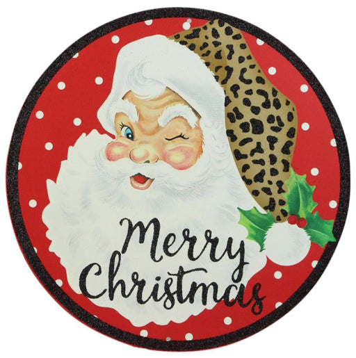 The 12Dia Merry Christmas/Santa Sign (Red/White/Black/Tan, MD0736) features a circular red metal design with white polka dots, a winking Santa with a leopard-print trim hat and holly, and Merry Christmas in black cursive below.
