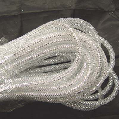 A coiled length of White Silver Foil Deco Flex Mesh Tubular Ribbon RE300440 rests on a dark surface, showcasing its transparent, braided mesh pattern and plastic vinyl-like appearance.