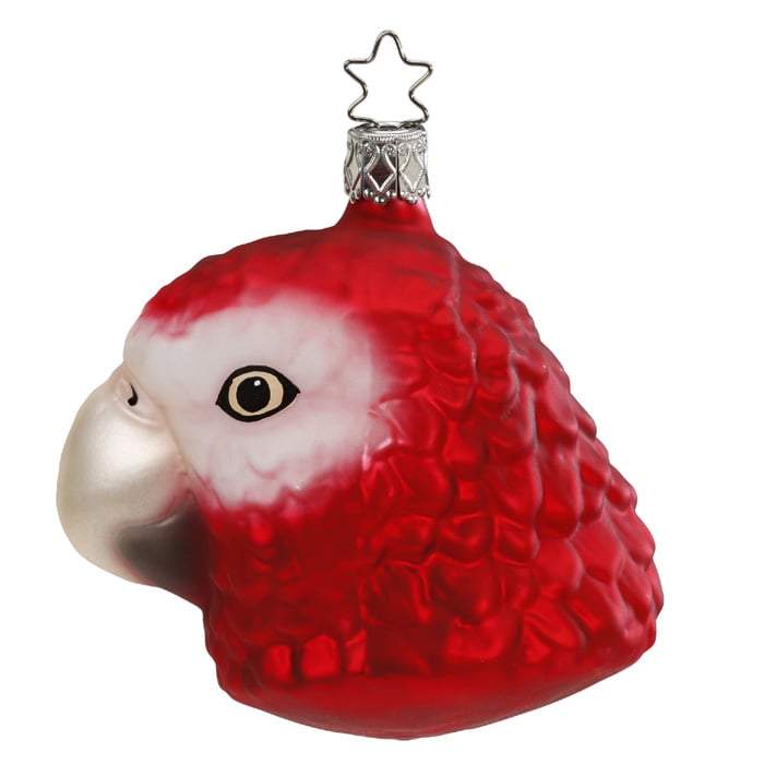 The Red Tropics Parrot Head Christmas Ornament by Inge-Glas (1-094-16) features a handmade glass design shaped like a red parrots head with a silver beak and a metal hanging loop.