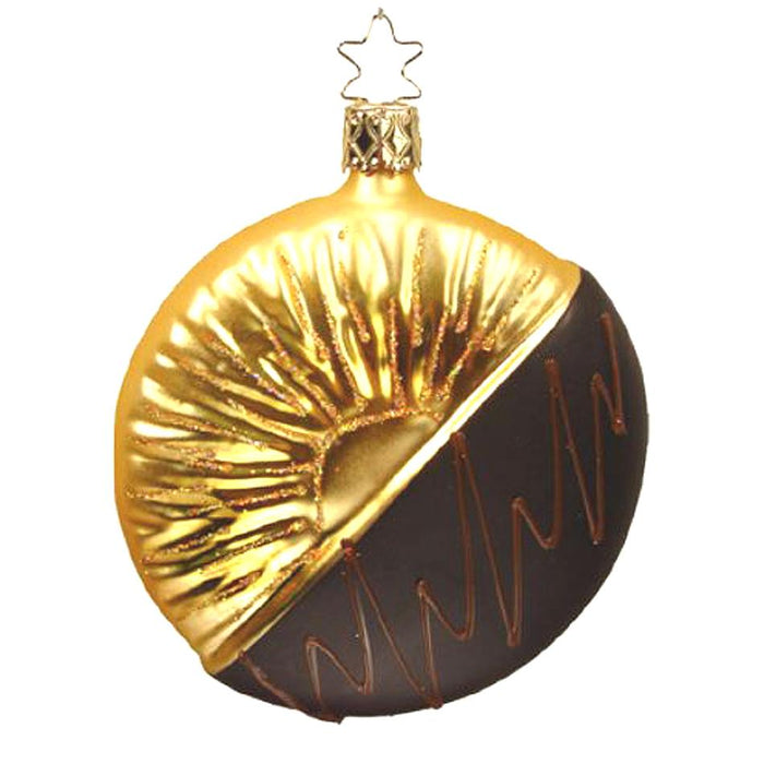 The Dark Chocolate Dipped Pineapple Slice Ornament by Inge-Glas (1-249-08) features shiny gold sun rays on one side and matte dark brown like chocolate on the other, finished with a gold cap and star-shaped loop for hanging.