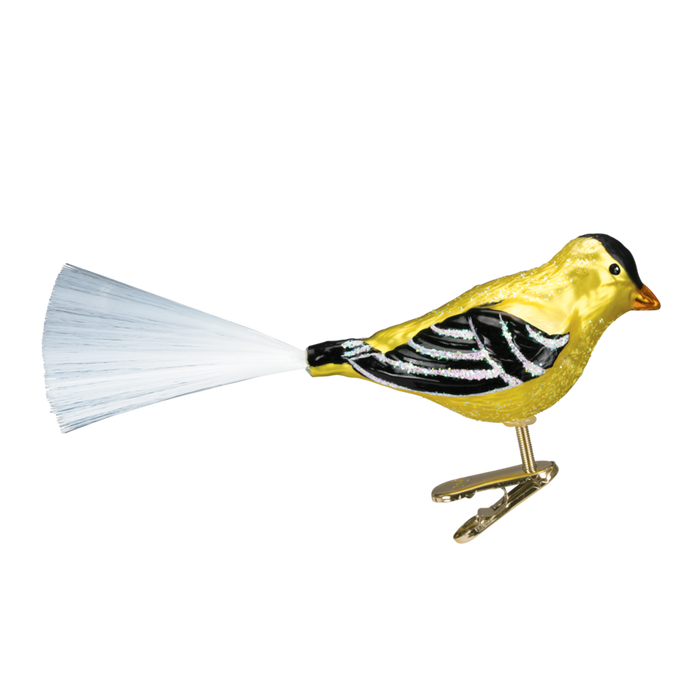 The Western Goldfinch 18038 Old World Christmas Ornament showcases a yellow and black bird with a white feathery tail and metal clip for easy attachment, displayed against a plain white background.
