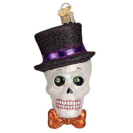 The Top Hat Skeleton 26068 Old World Christmas Ornament features a glittery skull with green eyes, a black top hat with a purple band, and an orange bow tie—ideal as festive Halloween or Skeleton Christmas decor.
