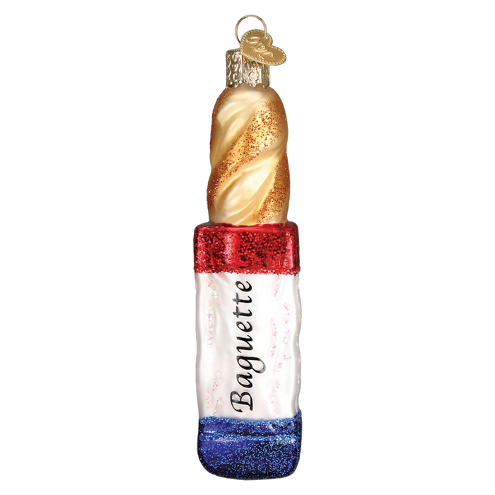 The Baguette Bread 32312 Old World Christmas Ornament is a hand-painted glass decoration shaped like a baguette in a clear bag with “Baguette” on front, featuring red, white, and blue glitter accents inspired by the French flag.
