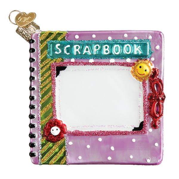 A vibrant scrapbook ornament with a purple, glittery, polka dot cover featuring a smiley face, flower, ribbon, and SCRAPBOOK text—perfect as the Scrapbook 32371 Old World Christmas Ornament.