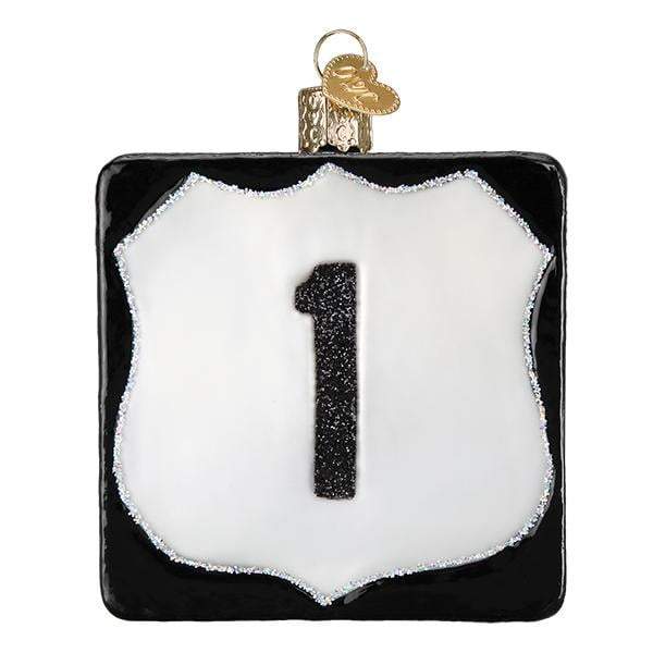 The Route 1 36255 Old World Christmas Ornament is a hand-painted glass decoration inspired by a highway sign, featuring a black border, white shield with bold black "1," and a gold loop for hanging.