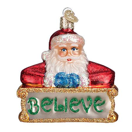The Believe Santa 40262 Old World Christmas Ornament features Santa in his classic red suit holding a green glittery "BELIEVE" sign with gold accents, inspired by the charm of traditional Old World Christmas glass ornaments.