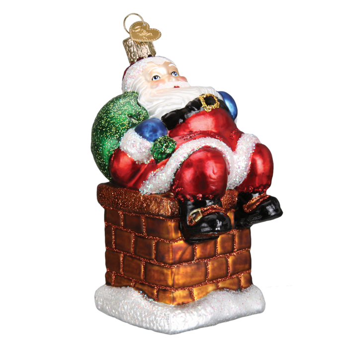 The Chimney Stop Santa 40297 Old World Christmas Ornament is a hand-painted glass decoration showing Santa in a glittery brick chimney with his red suit, black boots, green sack, and a gold loop for hanging.