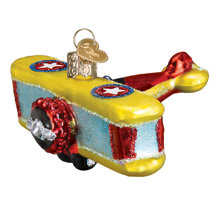 The Biplane Old World Christmas Ornament 46072 features glittery red, yellow, and blue colors, white stars on the wings, a gold hanging cap, and hand-painted glass details—perfect for adding festive charm to your holiday tree.