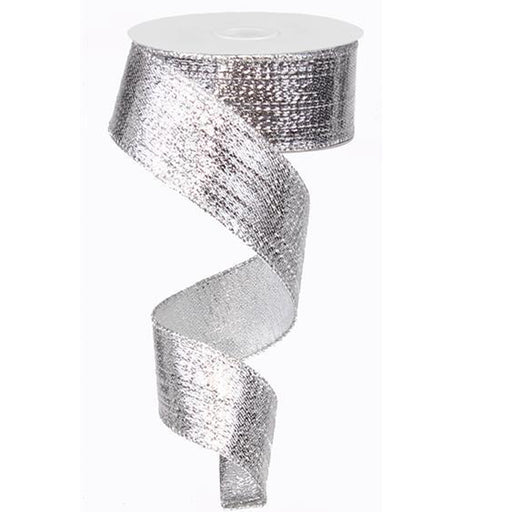 A spool of 1.5 Silver Metallic Ribbon RG0139926 with a textured, shiny surface hangs in a graceful spiral against a white background.