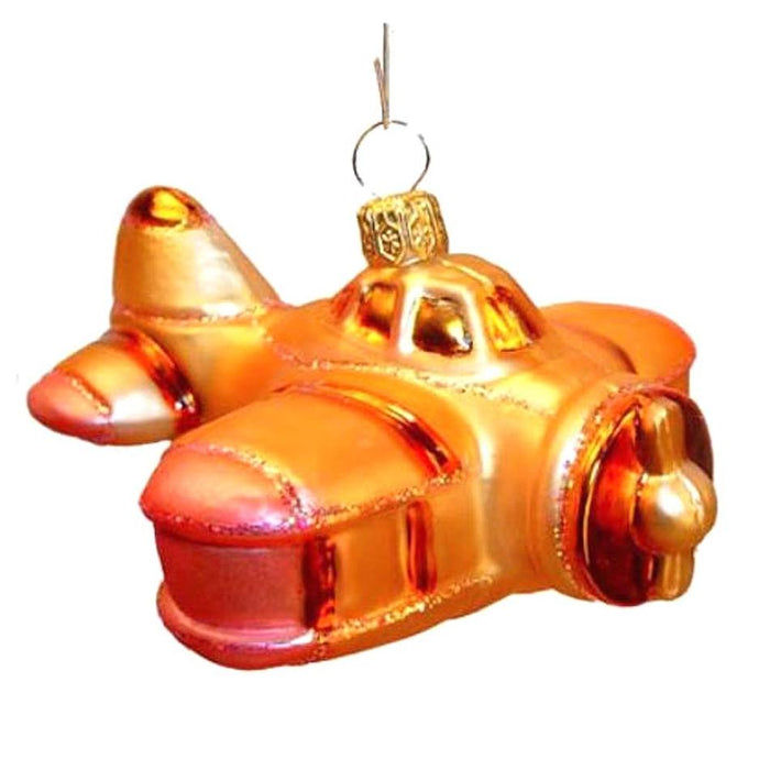 The Orange Bi-Plane Varsovia Christmas Ornament is a shiny, mouth blown glass ornament from Poland, featuring orange and gold colors with a top hook for hanging, shown against a white background.